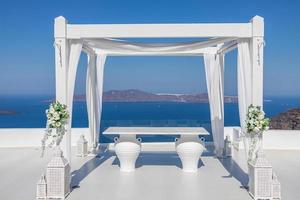 Wedding decorations with roses on the background of the sea, Greece, Santorini. Romantic white architecture, decor, summer travel, destination wedding