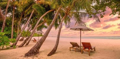 hermosa playa. sillas en la playa de arena cerca del mar. concepto de vacaciones y vacaciones de verano para el turismo. paisaje tropical inspirador. paisaje tranquilo, playa relajante, diseño de paisaje tropical foto