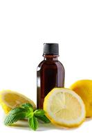 cosméticos para terapia de spa. botella de aceite aromático con limón y menta sobre fondo blanco. foto