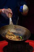 un chef prepara comida china en un festival de comida callejera. foto