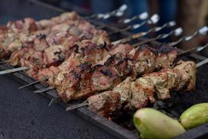 Grilled skewers of meat on the coals, with smoke. street food. photo