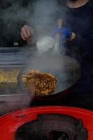 un chef prepara comida china en un festival de comida callejera. foto