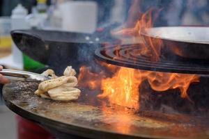 Cooking shrimp, prawn skewers on grill at street food festival - close up