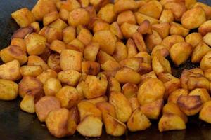 Chunks of fried potatoes in a large skillet during the street food festival. photo