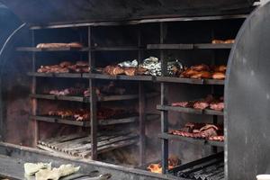 brochetas de carne a la parrilla sobre las brasas, con humo. comida de la calle. foto