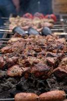 Grilled skewers of meat on the coals, with smoke. street food. photo