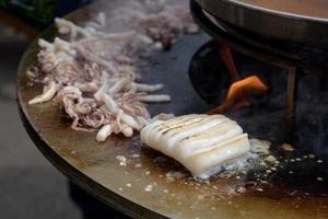 Cooking shrimp, prawn skewers on grill at street food festival - close up photo