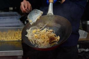 un chef prepara comida china en un festival de comida callejera. foto