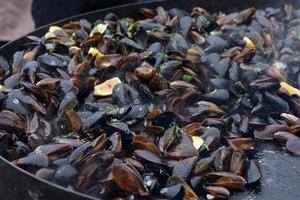 Close up of cooked mussels at a street food festival, ready to eat seafood photographed with soft focus