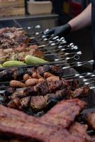 brochetas de carne a la parrilla sobre las brasas, con humo. comida de la calle. foto