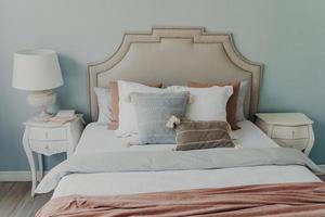 cómodo interior de dormitorio y textil. almohadas suaves en la cama. concepto de descanso en casa en una habitación acogedora. foto