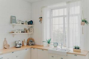 Domestic family kitchen. Brightly lit scandinavian kitchen interior with window. Modern apartment. photo