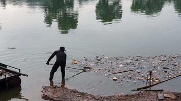 South Tangerang, Indonesia - March 7, 2022. Janitor picks up plastic waste in Situ Gintung lake Footage activity video