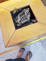 Woman throws her flip-flops sandals into a garbage can. photo