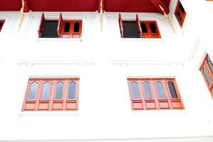 Red brown wood windows and white wall, retro style windows in rectangle shape, Thailand. photo