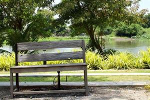 Old wooden bench in park and blur canal background with shadow on bench. photo