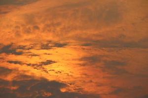 la luz del sol en las nubes esponjosas en el cielo nocturno y el fondo de la cubierta de nubes grises finas. foto