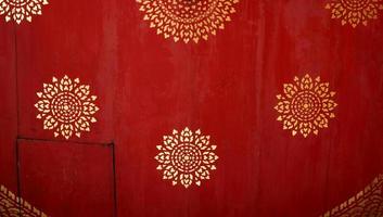 Golden Thai native pattern on red painted wood background, favorite ancient pattern in round shape, Thailand. photo