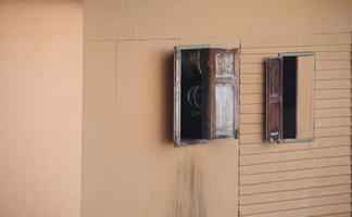 Old window open on light brown and smooth surface wall. Retro style window of wood house in Thailand. Beside view. photo