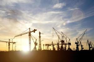 Crane concept in the construction industry. The silhouette of the crane in the construction site photo