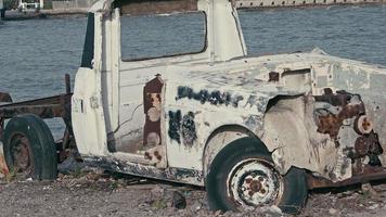 ruïnes van geruïneerde roestige pick-up door de kustbeelden. video