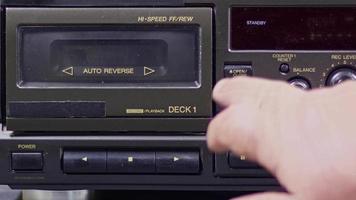 Male Hand Ejecting Cassette from Old Cassette Player