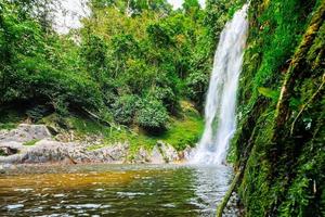 A large waterfall in the humid tropical forest of Thailand photo