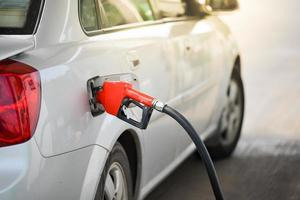 coches aparcados durante el repostaje. inyector de combustible en la bomba de aceite foto