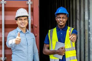 los trabajadores y el gerente dan el visto bueno después de la entrega exitosa de mercancías en el barco, donde se encuentran en una zona portuaria con muchos contenedores foto