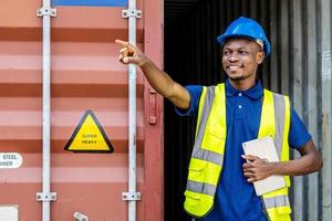 Seaport inspector busy with in-checking on cargo and pointing to position loading Containers box from Cargo freight ship at Cargo container shipping on a large commercial shipping dock photo