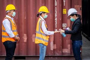 Female foreman wearing a mask is spraying alcohol hand sanitizer, They stood in line, washed their hands and measured the temperature before entering the event to prevent the virus photo