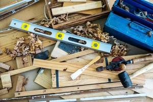 imagen de fondo de la estación de trabajo de carpinteros, mesa de trabajo de carpinteros con diferentes herramientas, corte de madera, indicador de nivel de agua con virutas de madera