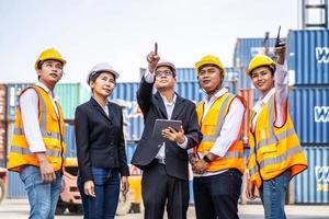 The Asian construction foreman pointed out and discussed new projects for engineers and container workers at the container warehouse. Business Freight Forwarding Logistics Corporate Teamwork Success photo