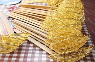 Strainer to boil noodles traditional style on table for sale, handle made from bamboo, Thailand. photo