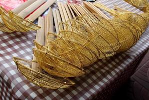 Group of yellow strainer to boil noodles traditional style on table for sale, handle made from bamboo, Thailand. photo