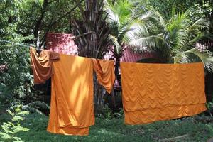 Robes are on wire in temple and dry clothes in the sun , Thailand. photo