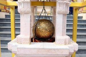 Luknimit is hanging in white cement frame and cover with gold leaves, Thailand. Luknimit is round stones buried in the ground to mark the sacred limits of a temple. photo