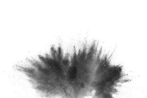 explosión de polvo negro. las partículas de carbón salpican sobre fondo blanco. primer plano de salpicaduras de partículas de polvo negro aisladas en el fondo. foto