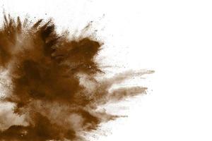 Abstract deep brown dust explosion on white background.  Freeze motion of coffee liked color dust splash. photo