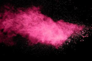Pink powder explosion on black background. photo