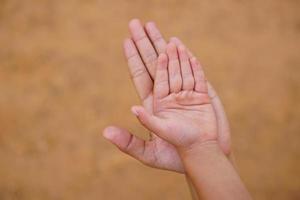 madre e hijo tomados de la mano para recibir algo foto