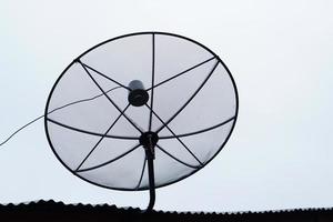 silhouette of a satellite dish on the roof of a house photo