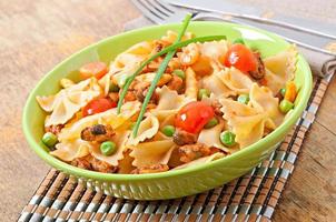 Farfalle pasta with seafood, cherry tomatoes and green peas photo