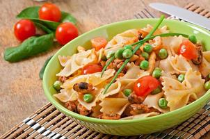 Farfalle pasta with seafood, cherry tomatoes and green peas photo