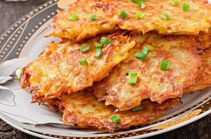 Fried potato pancakes on the old wooden background photo