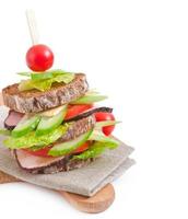 sándwich con jamón y verduras frescas sobre un fondo de madera foto