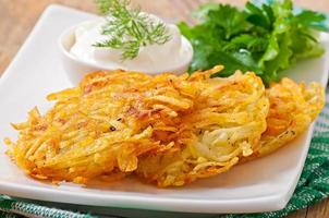 Fragrant potato pancakes with sour cream and herbs photo