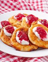 Pancakes of cottage cheese with sour cream and raspberry jam
