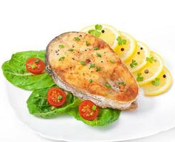 plato de pescado - filete de pescado frito con verduras sobre fondo blanco