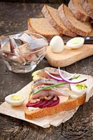 Sandwich of rye bread with herring, beets, onions and egg photo